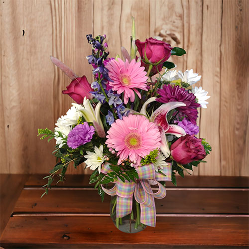 “Bundles of Love” A bouquet bundle of lovely roses, Gerber daisies, blue delphinium, carnations and lilies. $75.