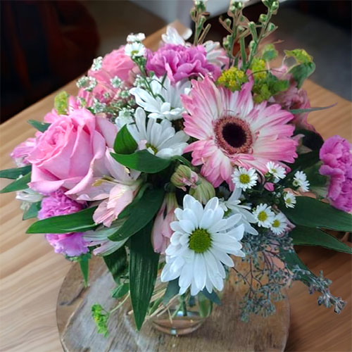 “Pretty In Pink”<br />
An amazing selection of pink and white Gerber daisies, roses, and daisies in a round clear vase. $50.