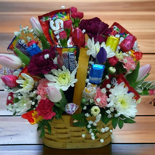 “As Sweet As You”<br />
A gorgeous basket of mixed spring flowers sprinkled with a selection of candy.  $60.
